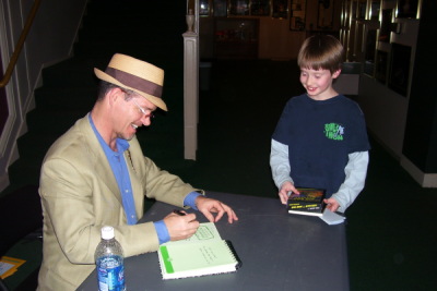 Bruce Hale signing a book for a young fan.